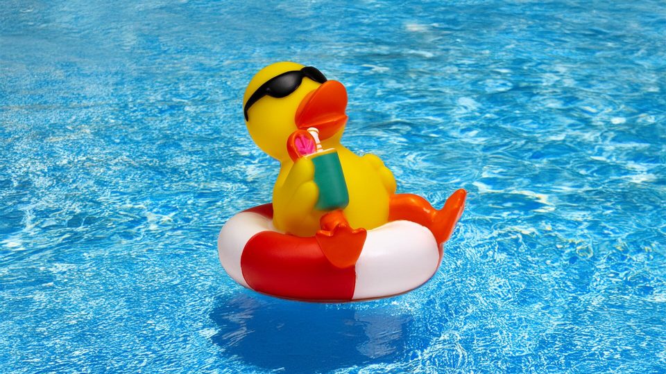 Gummiente im Schwimmring mit Cocktail – bearbeitet und mit Poolwasser-Hintergrund